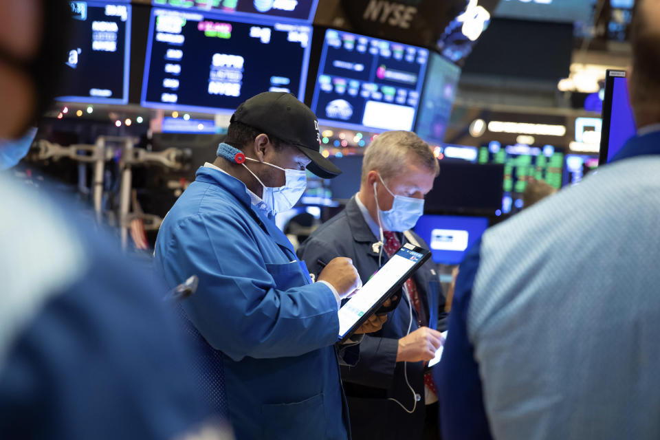 In this photo provided by the New York Stock Exchange, traders work on the floor, Thursday Dec. 3, 2020. U.S. stocks are inching further into record heights Thursday, as Wall Street continues to coast following its rocket ride last month powered by hopes for coming COVID-19 vaccines. (Nicole Pereira/New York Stock Exchange via AP)