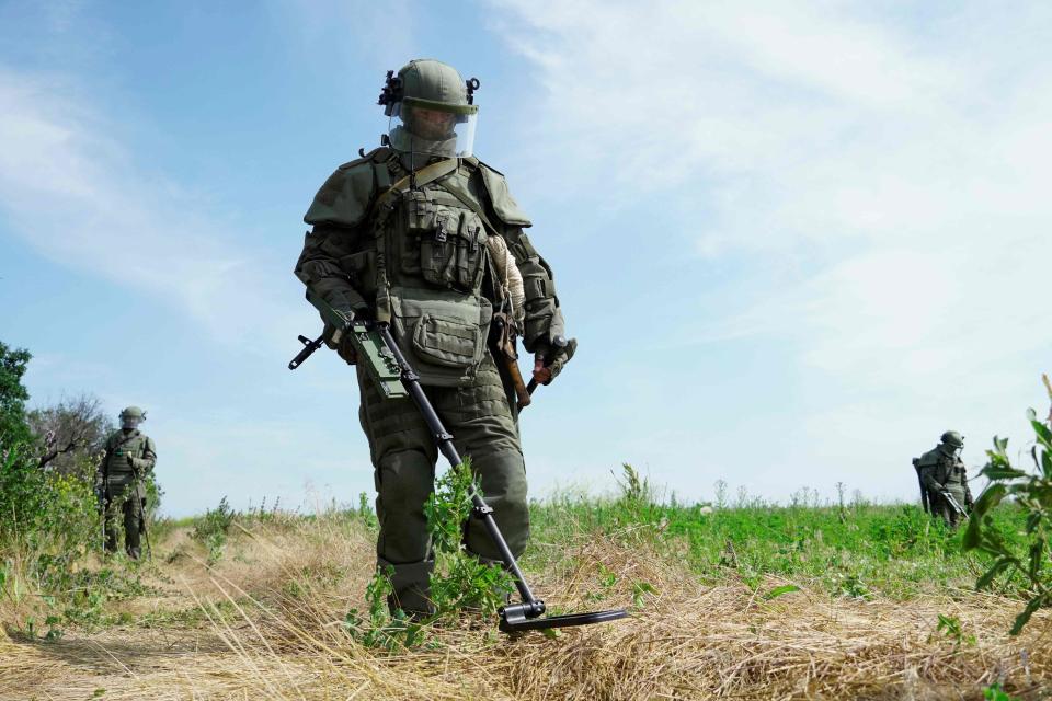 Russian servicemen wearing Explosive Ordnance Disposal (EOD) equipment demining a field at the Novoazovsk district in the Donetsk region (AFP via Getty Images)