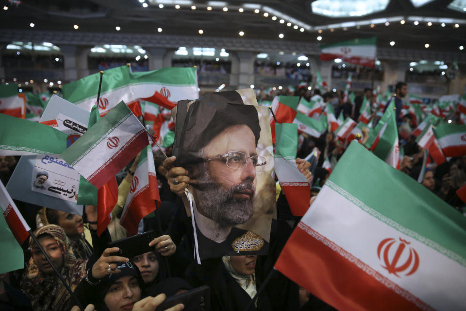 In this May 16, 2017 photo, supporters of hard-line cleric Ebrahim Raisi hold his photo and wave their country's flag during a 2017 presidential election rally in Tehran, Iran. On Thursday March 7, 2019, Iran's Supreme Leader Ayatollah Ali Khamenei named Raisi as the country's new judiciary chief. That’s sparked concern from rights activists over his involvement in the execution of thousands in the 1980s. Raisi’s selection comes after he was trounced by incumbent Hassan Rouhani in the country’s 2017 presidential election. (AP Photo/Vahid Salemi)