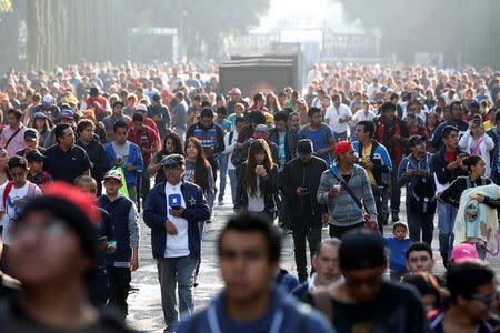 People walk with their mobile phones as some play Pokemon Go during a gathering to celebrate "Pokemon Day" in Mexico City, Mexico August 21, 2016. REUTERS/Carlos Jasso