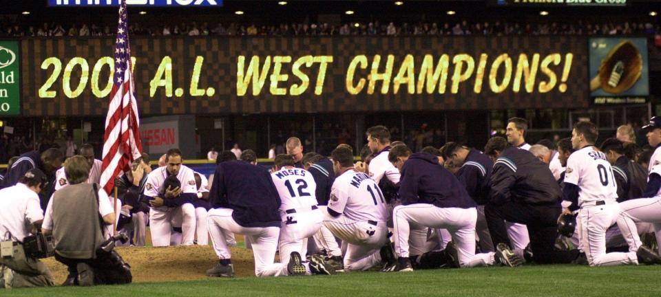 Mariners players have a moment of silence after clinching the AL West title on Sept. 19, 2001.