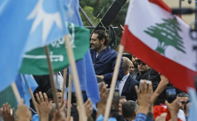 Supporters of Lebanese Prime Minister Saad Hariri wave the Lebanese flag and the blue colours of his Future Movement as they crowd outside his Beirut home to welcome him back to the country after nearly three weeks of absence cloaked in mystery