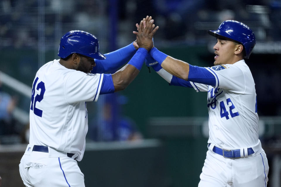 Kansas City Royals' Hanser Alberto, left, and Nicky Lopez celebrate after they scored when Whit Merrifield reached on a fielding error by Toronto Blue Jays' Cavan Biggio during the fourth inning of a baseball game Thursday, April 15, 2021, in Kansas City, Mo. (AP Photo/Charlie Riedel)