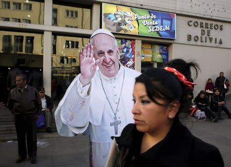 A woman walks next to a figure of Pope Francis in La Paz, July 7, 2015, ahead of his visit to Ecuador, Bolivia and Paraguay in his Latin-American tour. REUTERS/David Mercado