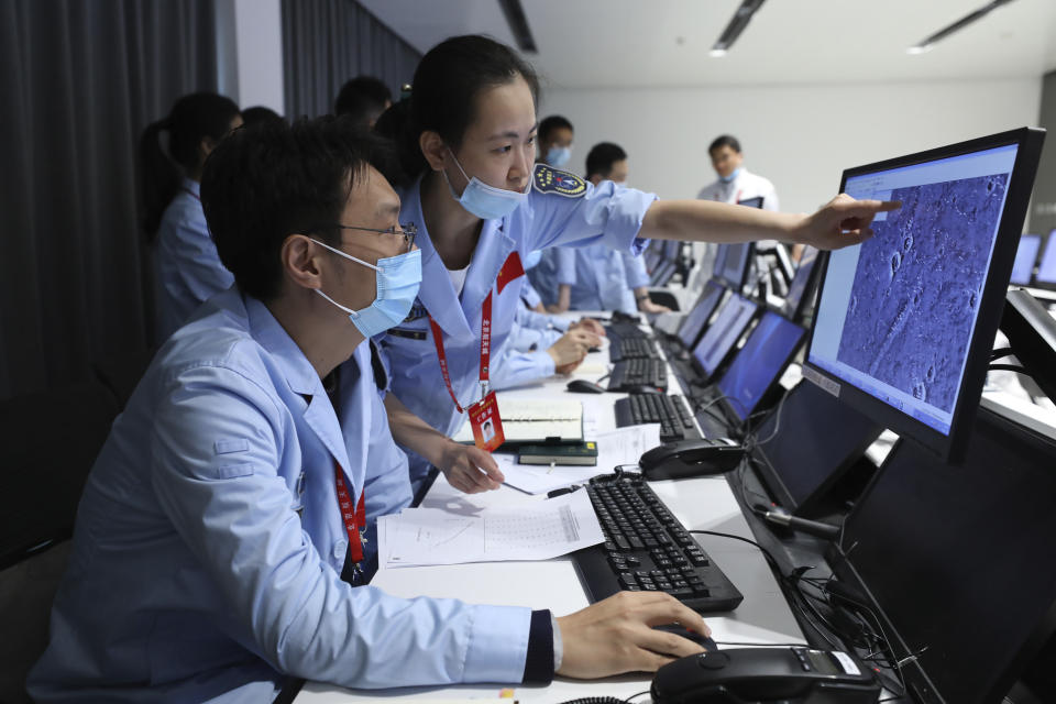 In this photo released by China's Xinhua News Agency, technicians work at the Beijing Aerospace Control Center in Beijing, Saturday, May 15, 2021. China landed a spacecraft on Mars for the first time on Saturday, a technically challenging feat more difficult than a moon landing, in the latest advance for its ambitious goals in space. (Jin Liwang/Xinhua via AP)