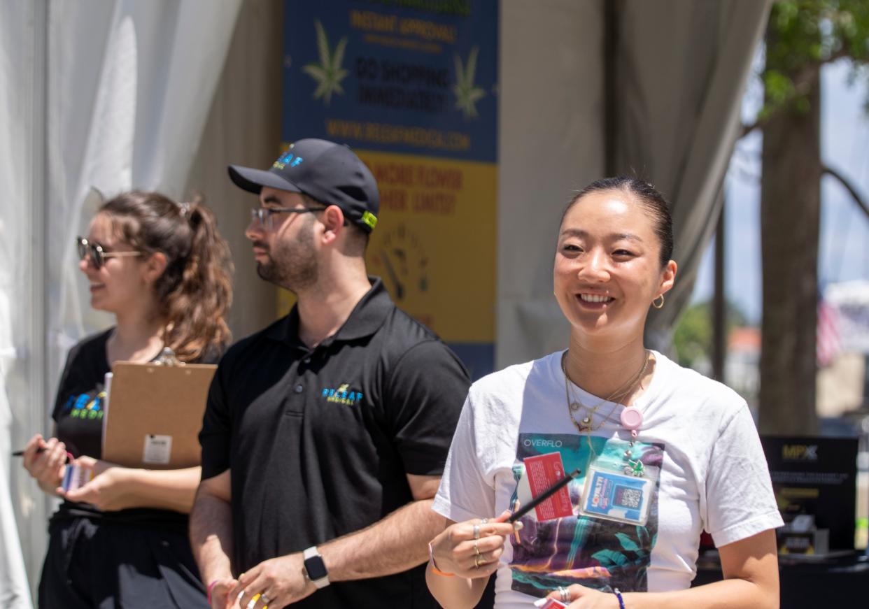 Jamie Zieman, the assistant manager for GrowHealthy, a cannabis dispensary in Stuart, right, and Hannah Weber and Alexander Santana of Releaf Medical at SunFest on Saturday.