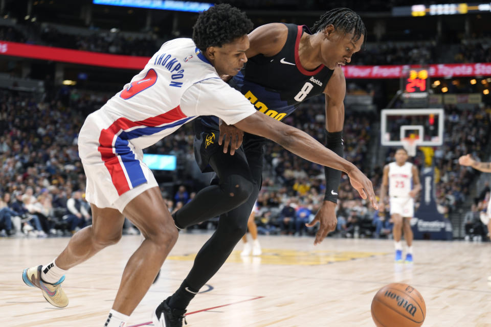Detroit Pistons forward Ausar Thompson, left, fights for control of the ball with Denver Nuggets forward Peyton Watson, right, in the second half of an NBA basketball game Sunday, Jan. 7, 2024, in Denver. (AP Photo/David Zalubowski)
