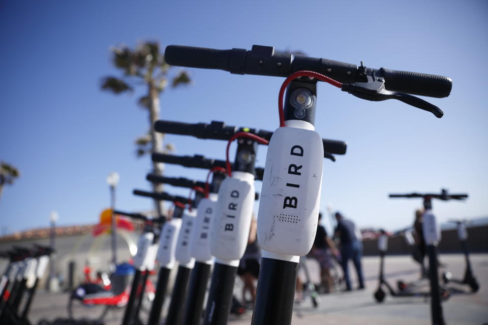 FILE - In this May 28, 2019, file photo Bird scooters are seen along Mission Beach boardwalk in San Diego. The two largest scooter companies in the U.S., Bird and Lime, generally place the responsibility for accidents on riders by listing in their rental agreements that riders relieve the companies of liability. Customers must agree to those terms to ride. Bird says riders are fully insured for anything that might happen as a result of a faulty Bird scooter. (AP Photo/Gregory Bull, File)