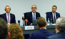 Chairman Rohner of Swiss bank Credit Suisse sits between Tiner, Chairman of the Audit Committee and Romerio, Managing Partner of Homburger during a news conference in Zurich