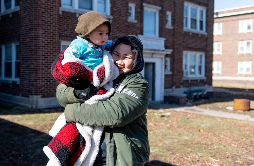 Chaw Noud carries her nephew outside of her apartment building Jan. 23 in Kansas City.