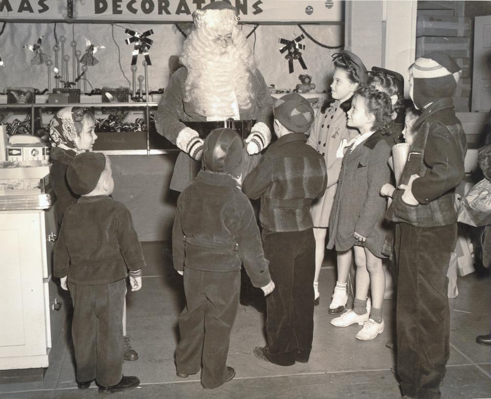 Children gather around "Santa Jim" Yellig of Santa Claus, Ind.