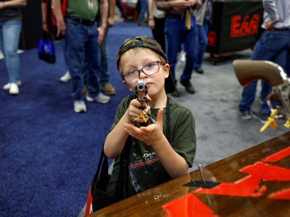 Hudson Eckart, 6, from Indiana, tries out a gun during the National Rifle Association (NRA) annual convention.