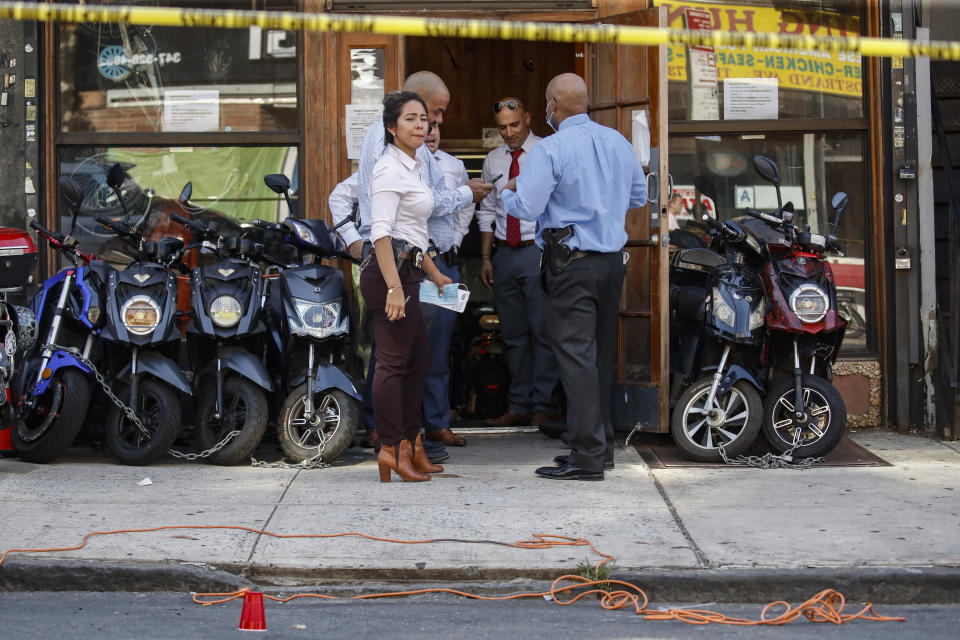 FILE - Police officers respond to a crime scene on Nostrand Avenue, where a 23-year-old man was discovered with gunshot wounds to his legs and torso before being transported to a hospital where he died from his injuries, in the Brooklyn borough of New York in a Saturday, July 18, 2020 file photo. President Donald Trump is again threatening to send federal agents to New York City if local authorities don't stop a surge of violence that has left seven people dead and more than 50 people shot since Friday, Aug. 14.(AP Photo/John Minchillo, File)