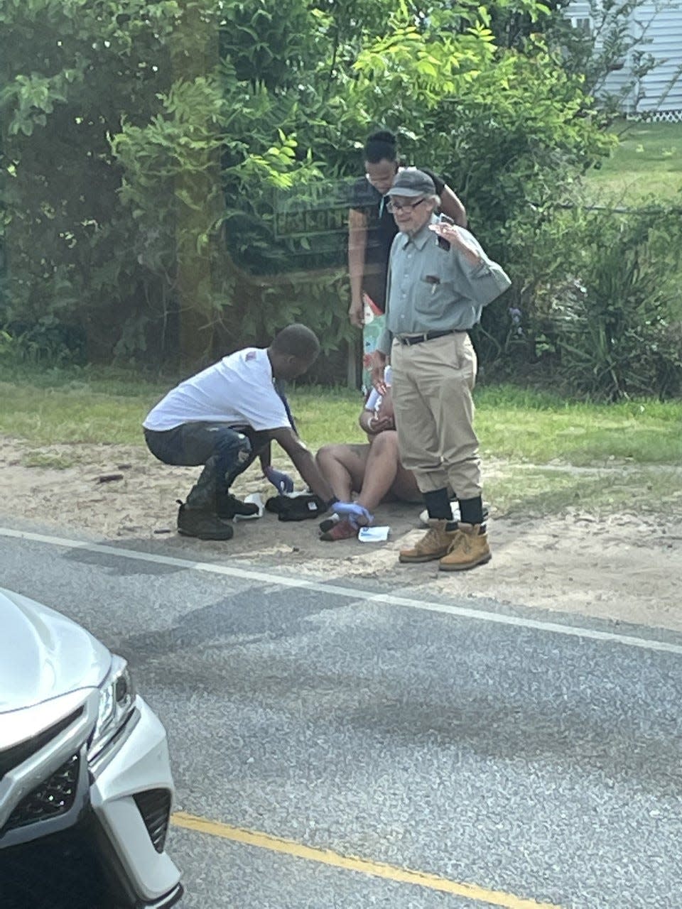 Cordarius Jones, left, assists a woman who was found lying in a roadway in Pensacola.