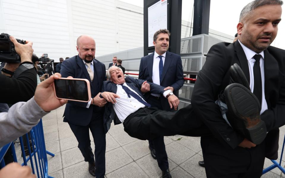 A protester is removed from the Shell AGM - Belinda Jiao