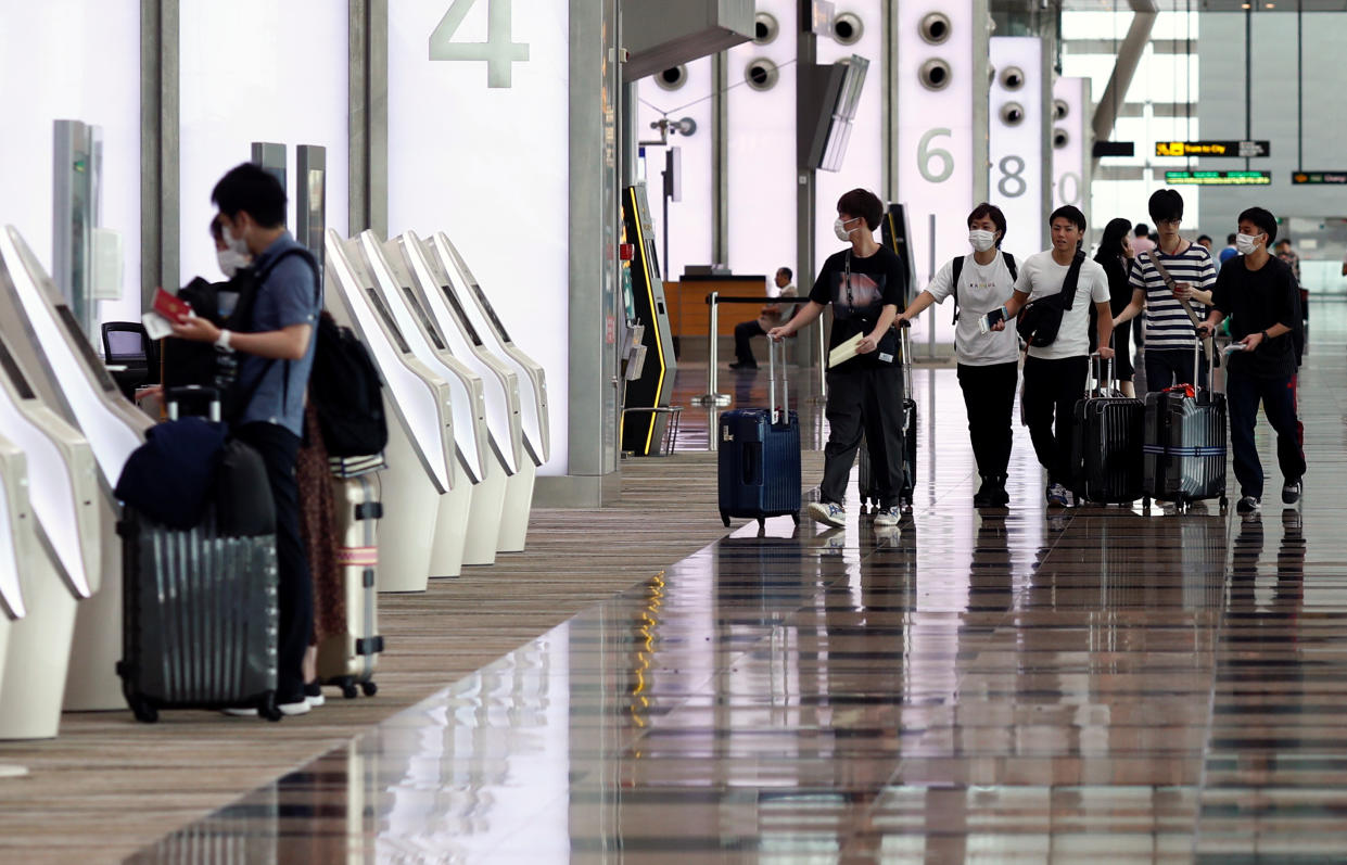 People wearing masks walk in Changi Airport in Singapore.