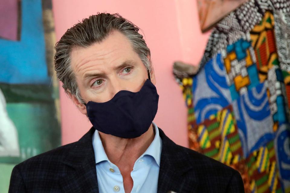 In this June 9, 2020, file photo, California Gov. Gavin Newsom wears a protective mask on his face while speaking to reporters at Miss Ollie's restaurant during the coronavirus outbreak in Oakland, Calif.