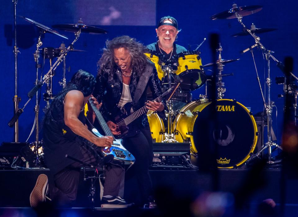 Metallica drummer Lars Ulrich smiles as lead guitarist Kirk Hammett circles bassist Robert Trujillo while they perform "For Whom the Bell Tolls" at the Power Trip Music Festival at the Empire Polo Club in Indio, Calif., Sunday, Oct. 8, 2023.