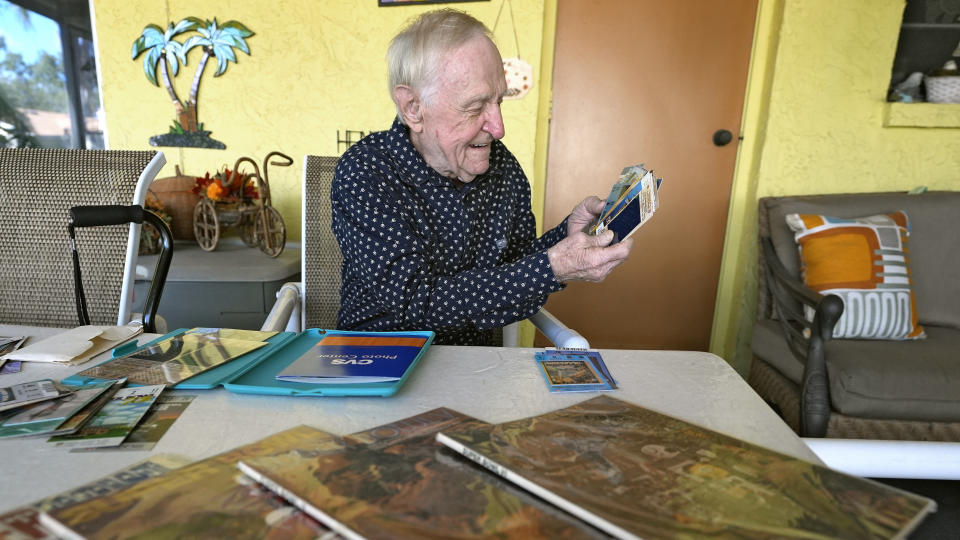 Tom Henschel looks over some of his Super Bowl memorabilia at his home Thursday, Jan. 25, 2024, in Tampa, Fla. Three football fans in their 80s are keeping their membership in the "never missed a Super Bowl" club. (AP Photo/Chris O'Meara)