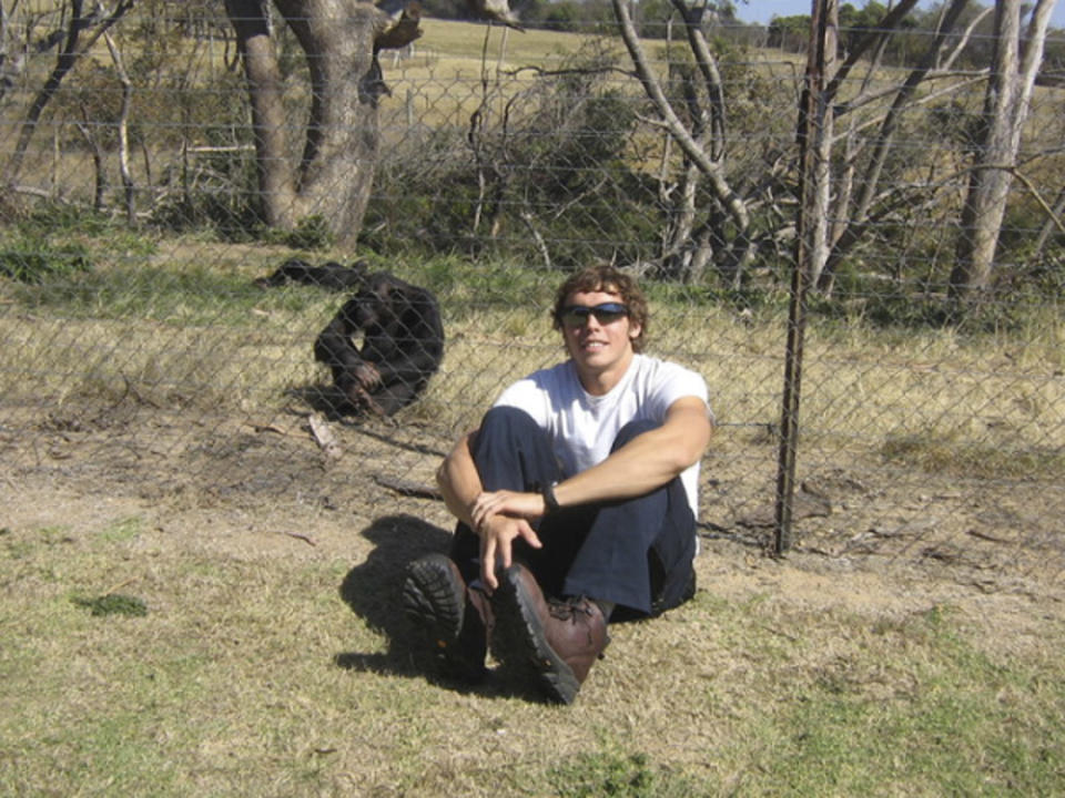 This undated photo provided by the Facebook group HelpAndrewOberle shows graduate student Andrew Oberle sitting with a chimp. Doctors are reporting improvement in the condition of Oberle, who was attacked by chimps he was studying in South Africa. (AP Photo/HelpAndrewOberle)