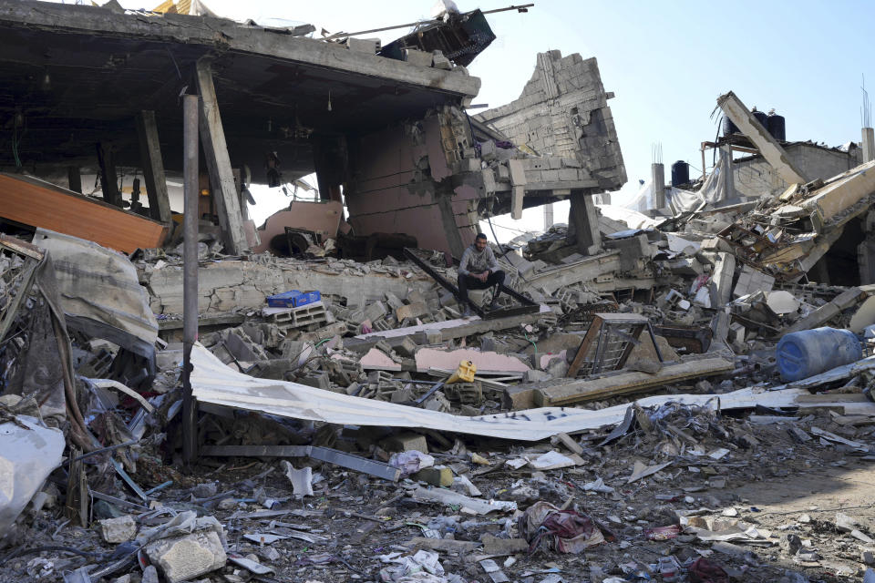 A Palestinian sits among destruction from the Israeli bombardment in the Nusseirat refugee camp in Gaza Strip, Friday, Jan. 19, 2024. (AP Photo/Adel Hana)