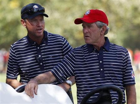 Former U.S. President George W. Bush (R) talks with U.S. captain Davis Love III during the afternoon four-ball round at the 39th Ryder Cup matches at the Medinah Country Club in Medinah, Illinois, September 29, 2012. REUTERS/Jeff Haynes