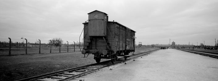 A wagon stands on the railway tracks, with the reception center in the distance.