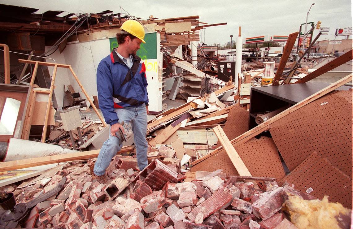 Dennis Wicks, owner and operator of the Color Wheel paint store at 3232 W. 7th St., looks over the damage to his store two days after a March 28, 2000, tornado. The site today is a block-long, four-story development that includes World of Beer.
