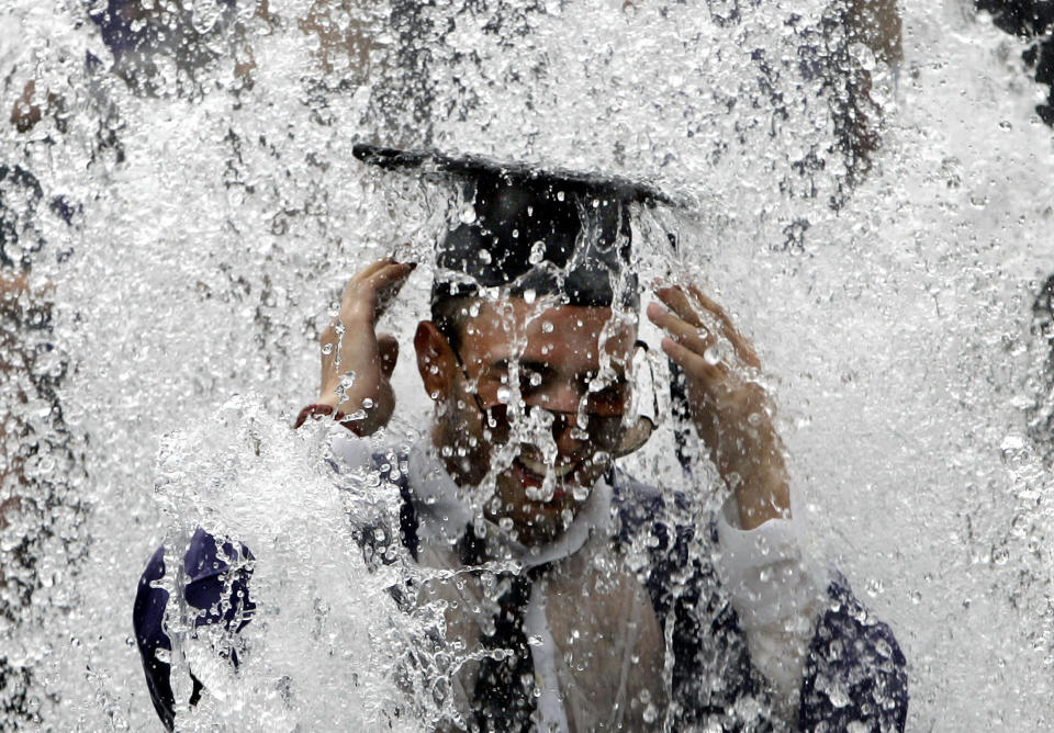 A New York University student celebrates in the Washington Square Park fountain after NYU's 175th graduation ceremonies in New York in this May 10, 2007 file photo. For some academics, the financial crisis is the ultimate 