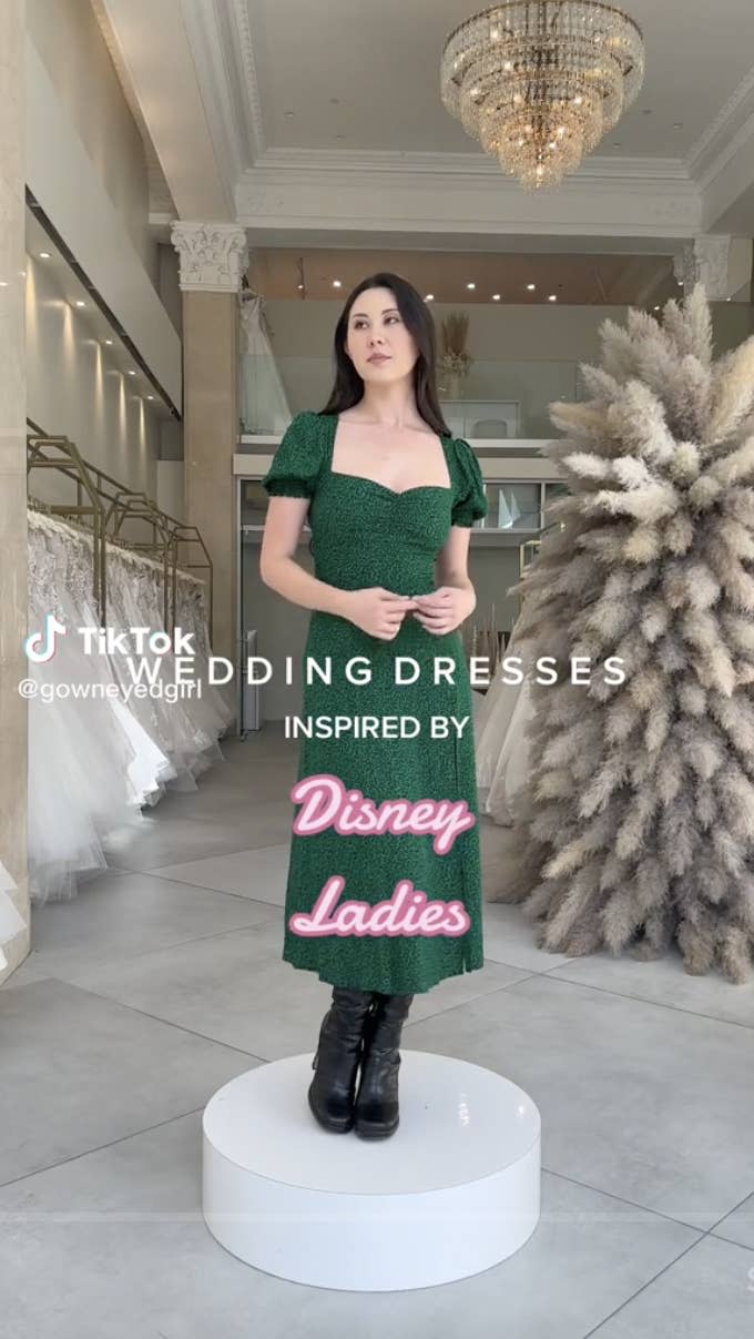 Kennedy on a pedestal in a bridal store wearing an ankle-length summer dress