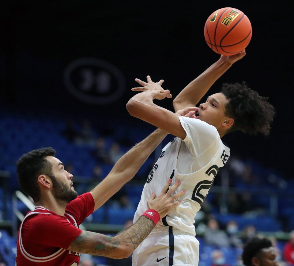 University of Akron forward Enrique Freeman (25) puts up a shot over Miami forward Elijah McNamara (33) during the first half of the Zips' 66-55 win Friday night at Rhodes Arena. [Jeff Lange/Beacon Journal]