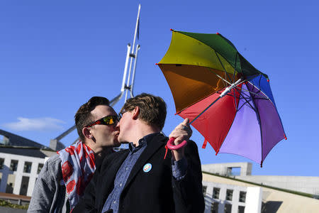 A couple kisses outside Parliament House during an equality rally in Canberra December 7, 2017. AAP/Lukas Coch/via REUTERS