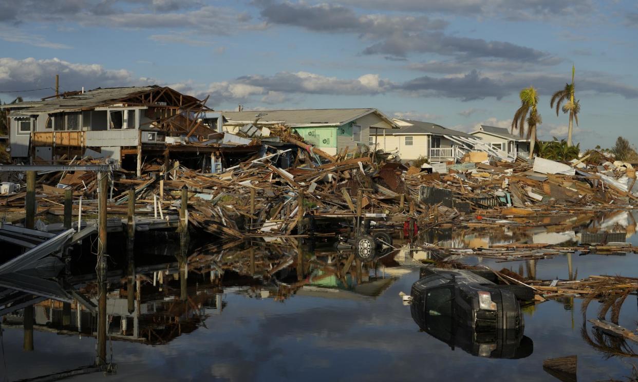 <span>Cars and debris from washed away homes line a canal in Fort Myers Beach, Florida, on 5 October 2022 – a week after the passage of Hurricane Ian.</span><span>Photograph: Rebecca Blackwell/AP</span>