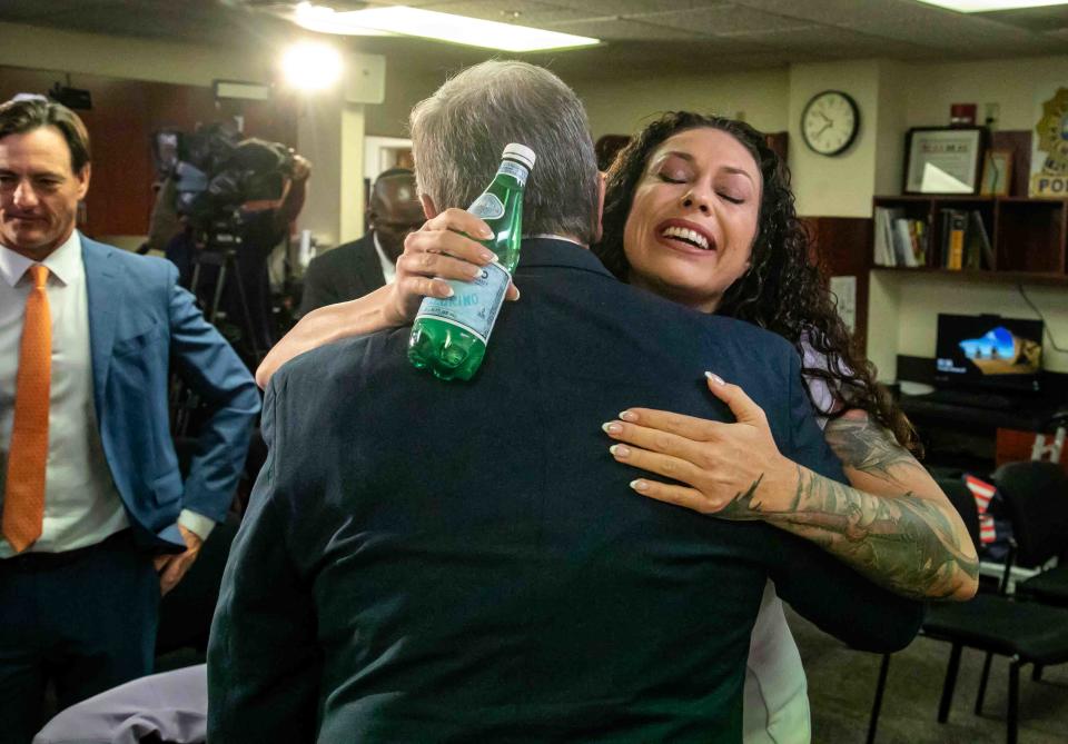 Jeffrey Epstein victim Hayley Robson receives a hug from former Palm Beach Police Chief Michael Reiter after the bill signing.