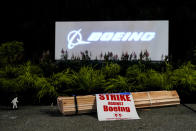 Signs and firewood sit in front of a Boeing sign as employees picket after union members voted overwhelmingly to reject a contract offer and go on strike Friday, Sept. 13, 2024, outside the company's factory in Renton, Wash. (AP Photo/Lindsey Wasson)