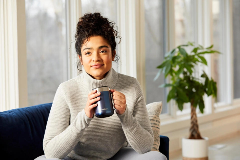 A person holding the mug by the handle