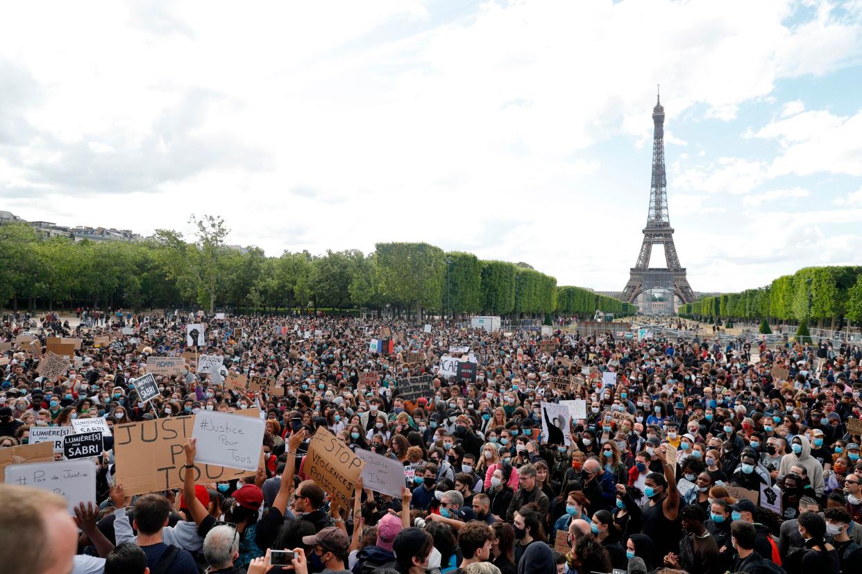 A protester holds a banner on Champ de Mars, in Paris, on June 6, 2020, as part of worldwide protests against racism and police brutality in the wake of the death of George Floyd, an unarmed black man killed by police in Minneapolis. (Photo: GEOFFROY VAN DER HASSELT via Getty Images)