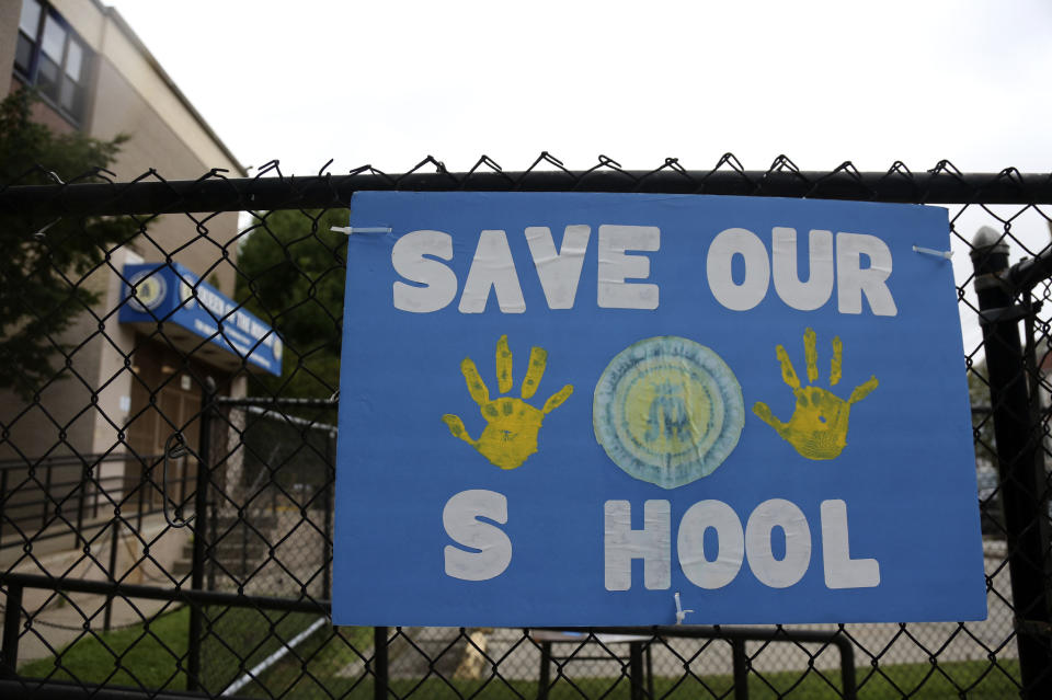 A sign made by parents and students of Queen of the Rosary Catholic Academy hangs on the fence outside the school in Brooklyn borough of New York, Tuesday, Aug. 4, 2020. Queen of the Rosary is one of six Catholic schools in Brooklyn and Queens that will permanently close at the end of August. Nationwide, more than 140 Catholic schools will not reopen in the fall. (AP Photo/Jessie Wardarski)