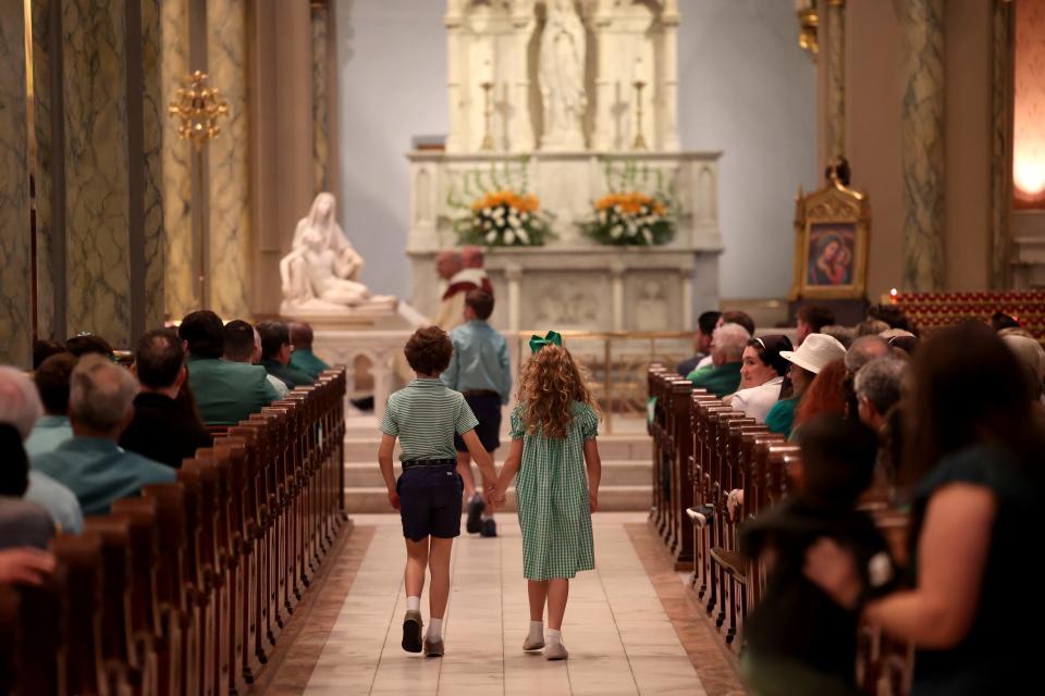Children walk down the aisle during the St. Patrick's Day Mass on Saturday, March 16, 2024 at the Cathedral Basilica of St. John The Baptist.
