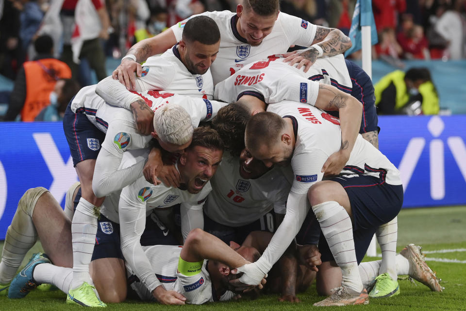 Harry Kane (abajo) es felicitado por sus compañeros de Inglaterra tras anotar en la prórroga de la semifinal de la Eurocopa ante Dinamarca, el miércoles 7 de julio de 2021 en Wembley (Laurence Griffiths/Pool Photo via AP)