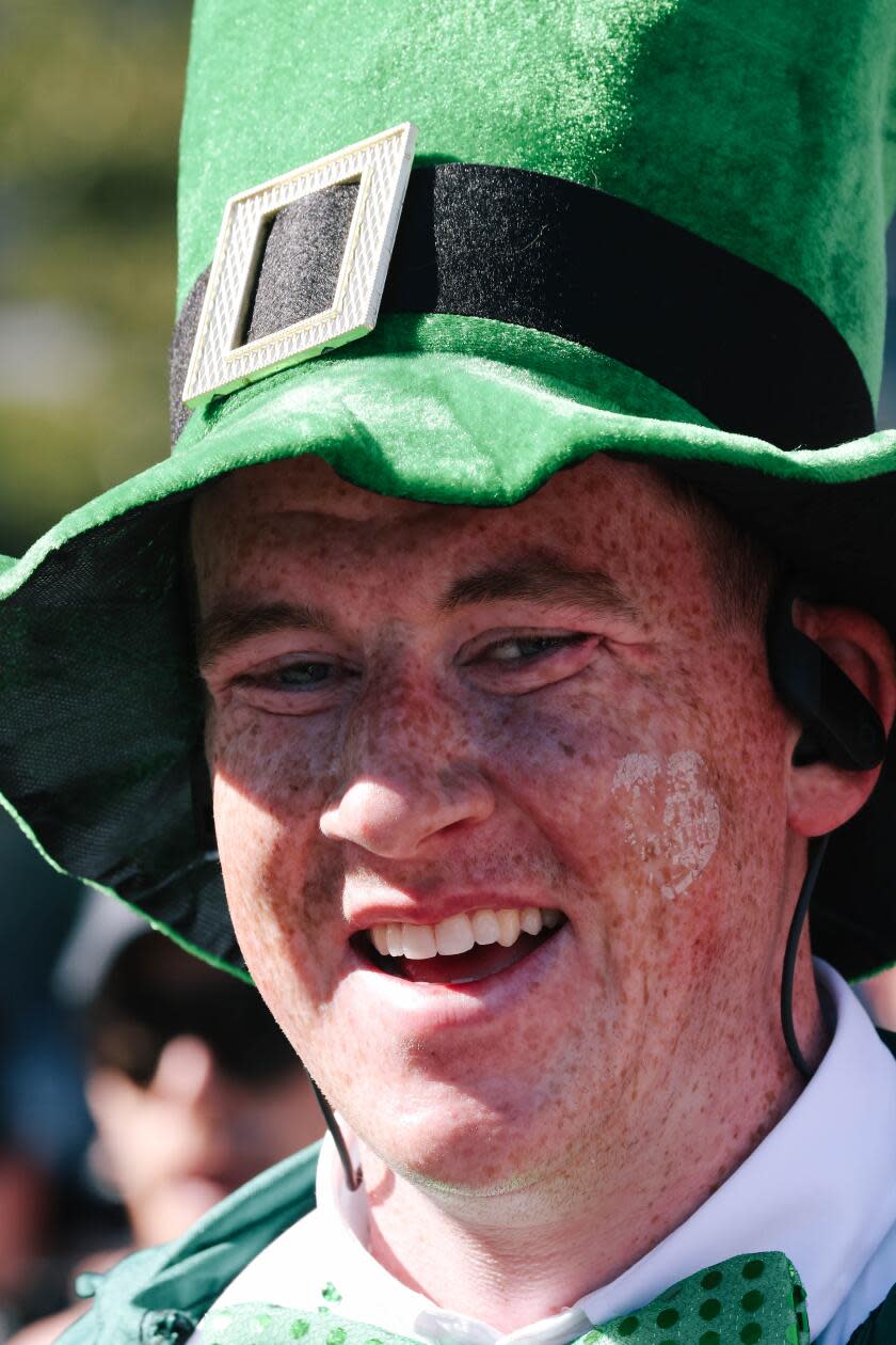 A runner crosses the finish line wearing clothing to celebrate St. Patricks Day