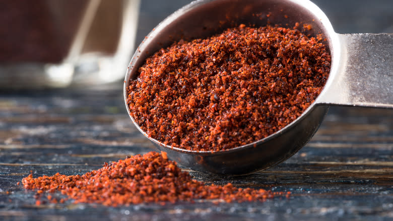 Chipotle powder pouring from metal scoop