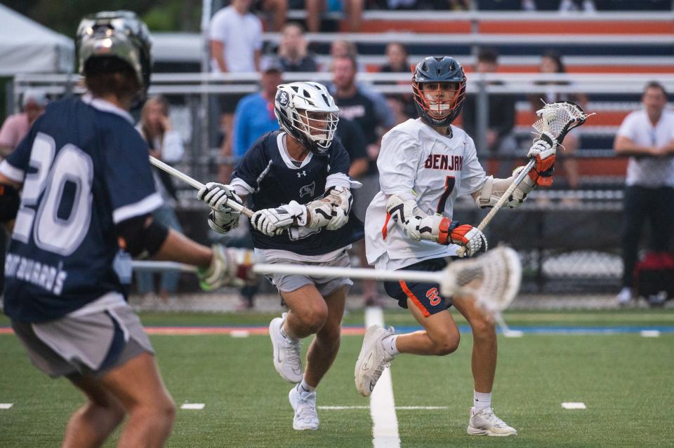 St. Edward's midfielder Reed Sternberg (27) carries the ball under pressure from Benjamin's Jack Kelleher (1) during the District 8-1A boys lacrosse championship game between St. Edward's and host Benjamin on Thursday, April 13, 2023, in Palm Beach Gardens, Fla. Final score, Benjamin, 12, St. Edward's, 9.