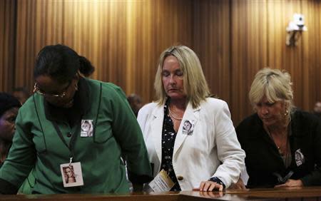Reeva Steenkamp's mother June (C) leaves the room when crime scene photographs of her daughter are shown during Oscar Pistorius' trial for the murder of girlfriend Reeva, at the North Gauteng High Court in Pretoria, March 17, 2014. REUTERS/Siphiwe Sibeko