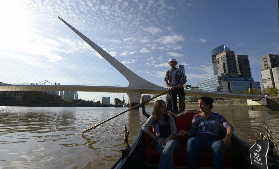 Un gondolero traslada a turistas en aguas de un canal del puerto de Buenos Aires, con el ‘Puente de la Mujer’ como fondo, el 30 de abril de 2015 en la capital argentina (AFP | Juan Mabromata)