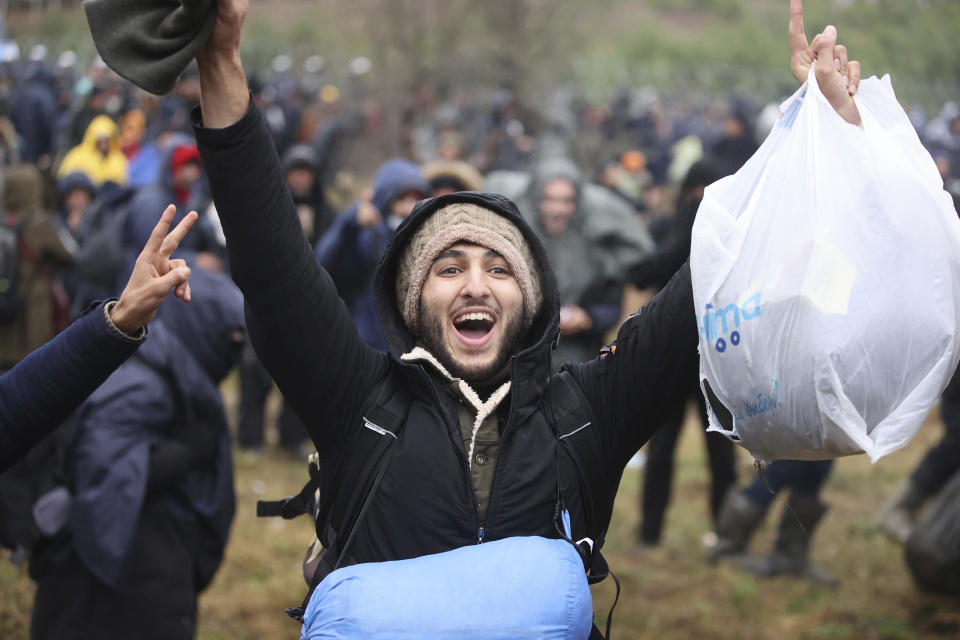 A man shouts slogans as he gathers with other migrants at the Belarus-Poland border near Grodno, Belarus, Monday, Nov. 8, 2021. Poland increased security at its border with Belarus, on the European Union's eastern border, after a large group of migrants in Belarus appeared to be congregating at a crossing point, officials said Monday. The development appeared to signal an escalation of a crisis that has being going on for months in which the autocratic regime of Belarus has encouraged migrants from the Middle East and elsewhere to illegally enter the European Union, at first through Lithuania and Latvia and now primarily through Poland. (Leonid Shcheglov/BelTA via AP)