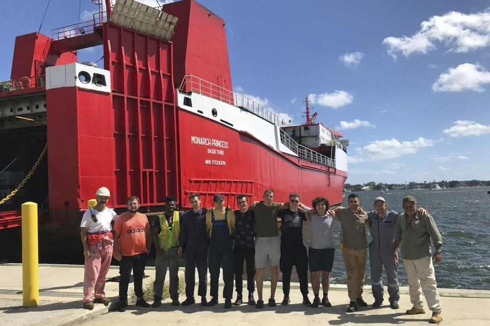 This photo provided by Ievgen Slautin of Ukraine, captain of the cargo ship Monarch Princess, shows him, second from left, with the six men who were with him on the ship abandoned by owners Teeters Agency & Stevedoring at the Port of Palm Beach in Riviera Beach, Fla., and other men in 2023. Left hanging by Teeters were the ships' crews of mostly Ukrainian seafarers, who suddenly had no way of sending money to families back home in what was now a war zone after Russia’s invasion. (Courtesy Ievgen Slautin via AP)