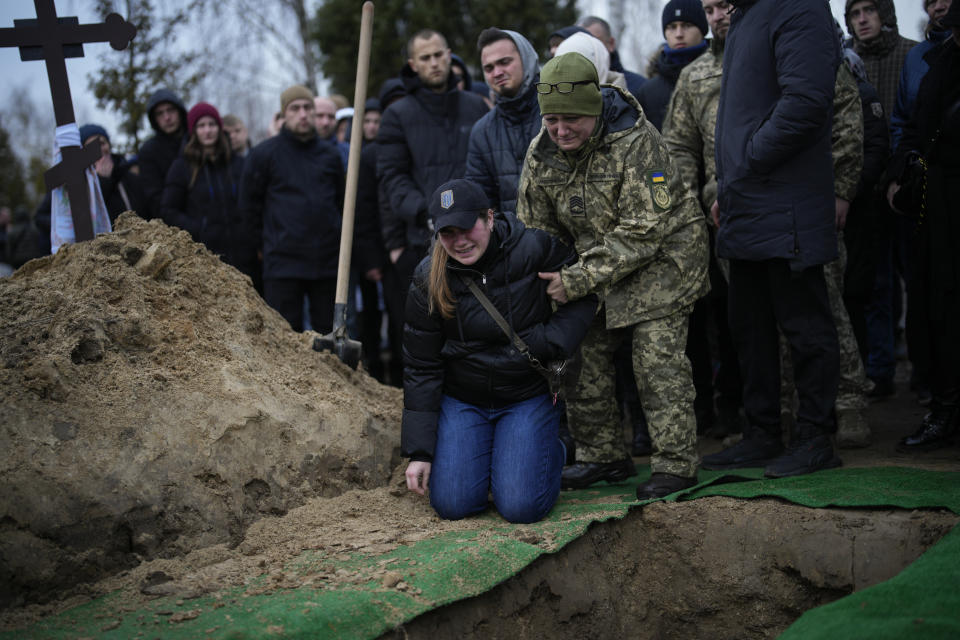 Anna Korostenska, 24, drops to her knees before the grave of her fiancee Oleksii Zavadskyi, a Ukrainian serviceman who died in combat on Jan. 15 in Bakhmut, during his funeral in Bucha, Ukraine, Thursday, Jan. 19, 2023. (AP Photo/Daniel Cole)