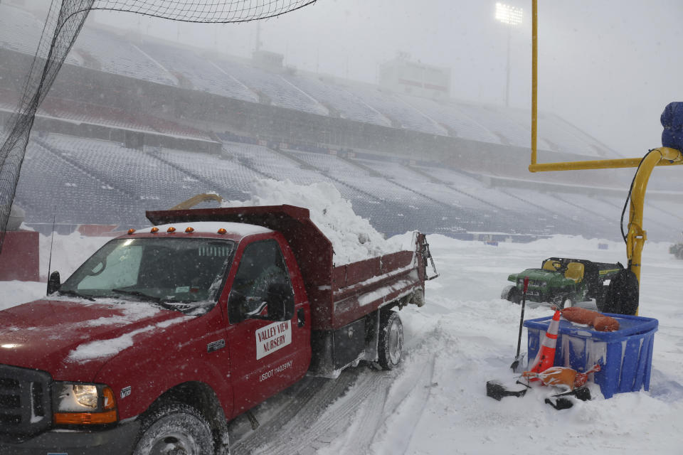 Workers remove snow from Highmark Stadium in Orchard Park, N.Y., Sunday Jan. 14, 2024. A potentially dangerous snowstorm that hit the Buffalo region on Saturday led the NFL to push back the Bills wild-card playoff game against the Pittsburgh Steelers from Sunday to Monday. New York Gov. Kathy Hochul and the NFL cited public safety concerns for the postponement, with up to 2 feet of snow projected to fall on the region over a 24- plus hour period. (AP Photo/ Jeffrey T. Barnes)