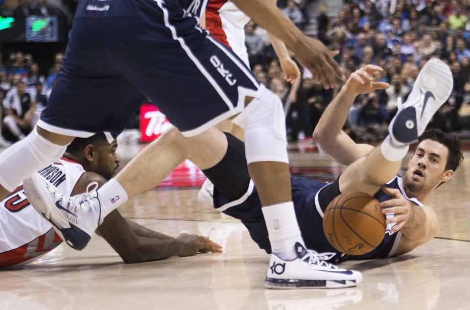 Toronto Raptors' Amir Johnson, left, battles for the loose ball against Oklahoma Thunder forward Nick Collison, right, during the first half of an NBA basketball game in Toronto on Friday, March 21, 2014. (AP Photo/The Canadian Press, Nathan Denette)